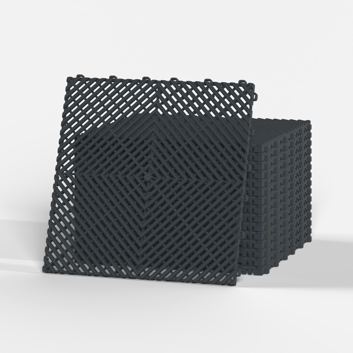 ULTRAGRID garage floor tile in Stealth Grey, standing in front of a stack
