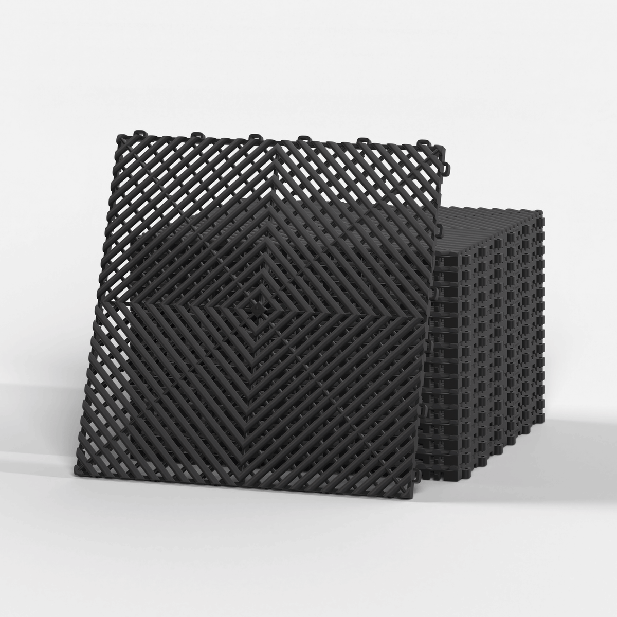 ULTRAGRID garage floor tile in Jet Black, standing in front of a stack