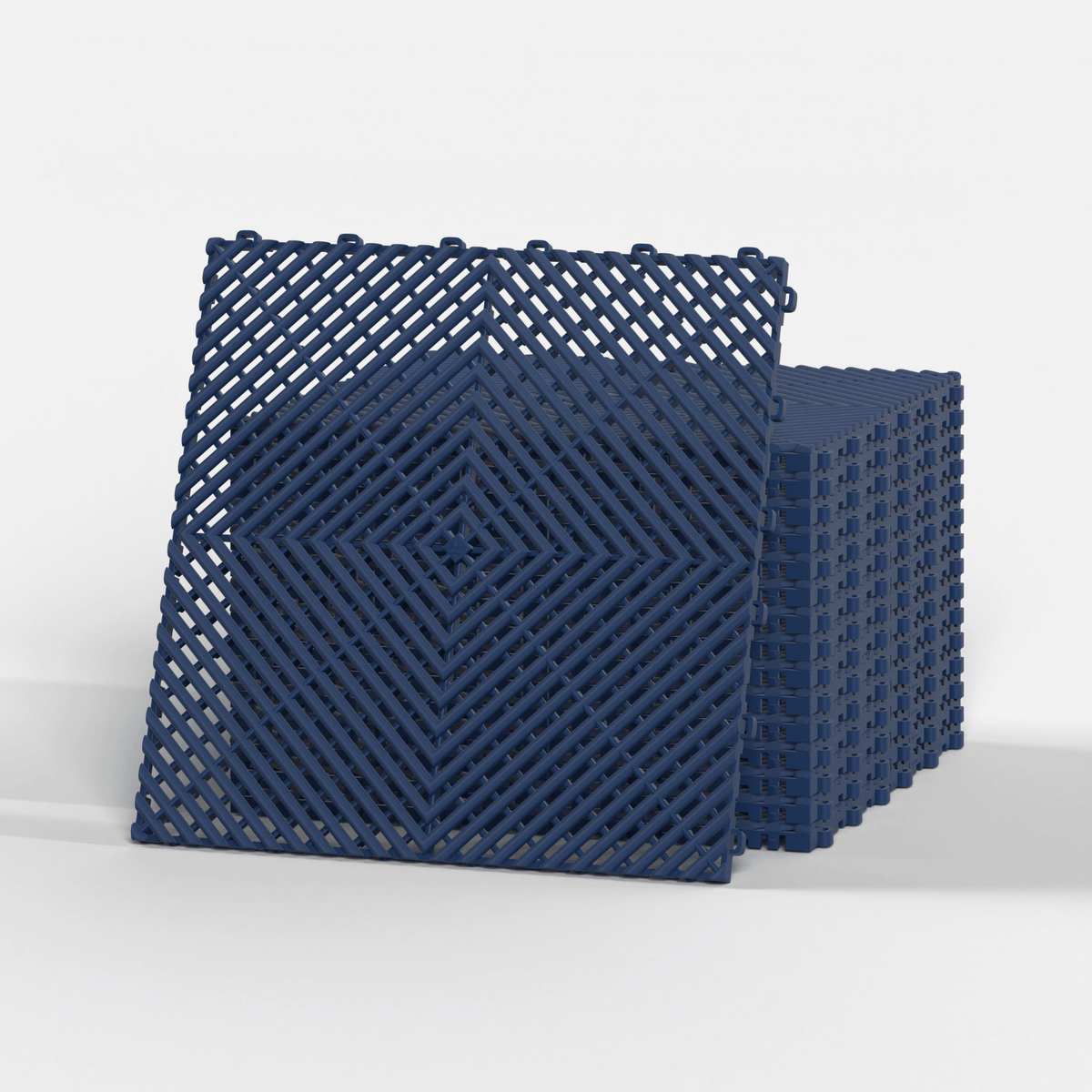 ULTRAGRID garage floor tile in Night Blue, standing in front of a stack