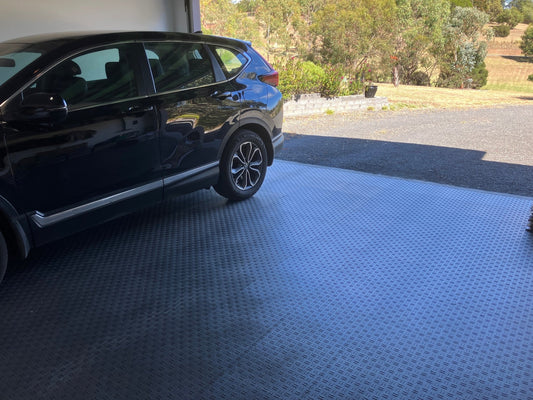 Heavy vehicle parked on Sleek Space interlocking garage floor tiles
