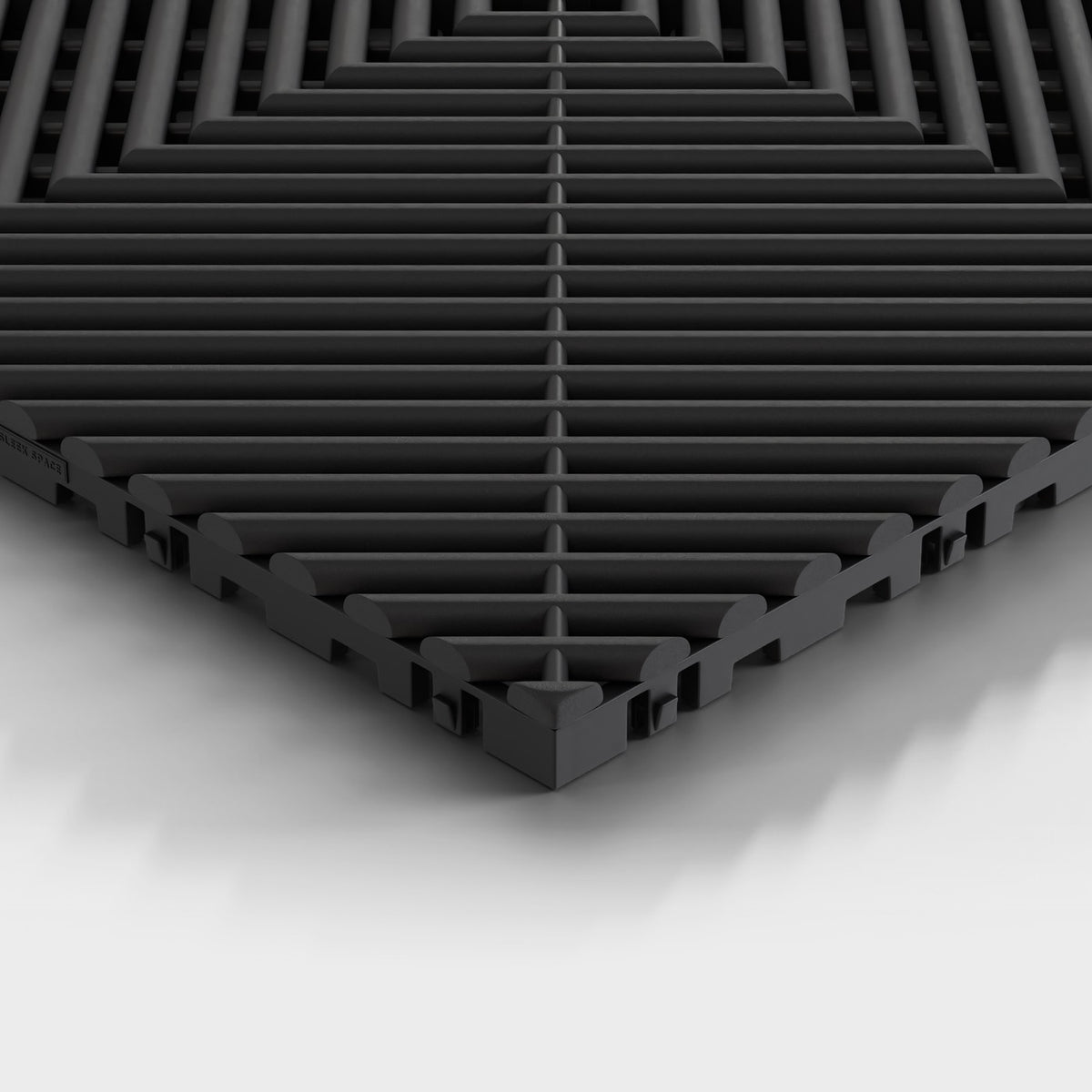 ULTRAGRID tile in Jet Black: one corner seen low, the open ribs and the legs under them