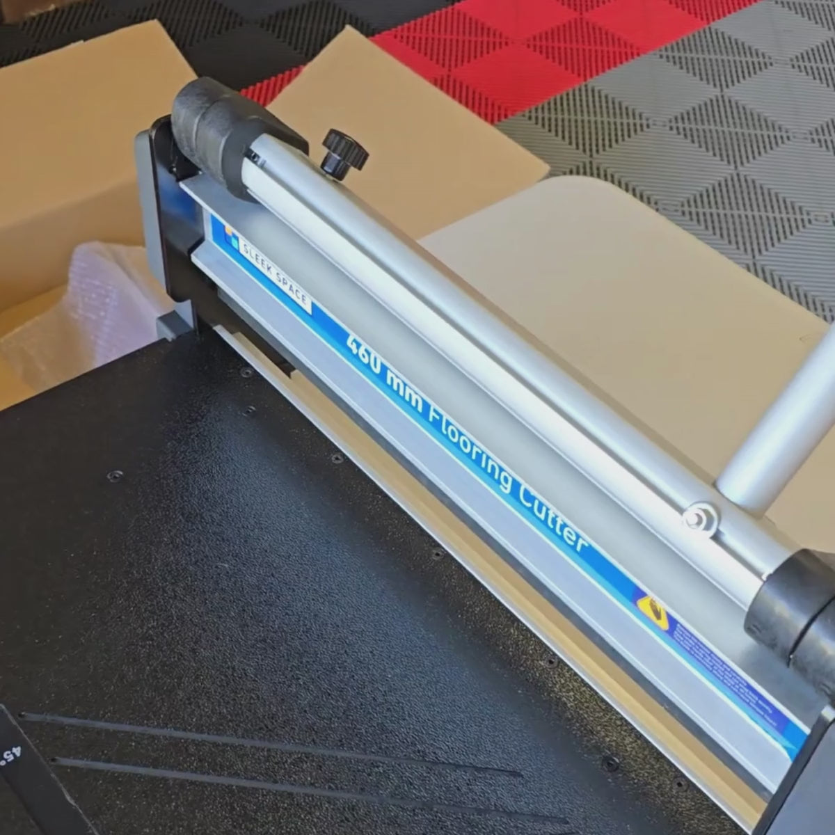 Film: the tile cutter cutting a garage floor tile in one pull
